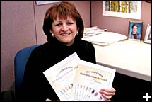 Photo de Lucie Cossette qui pose avec des exemplaires franais et anglais de son livre. Photo de Pascale Therriault.